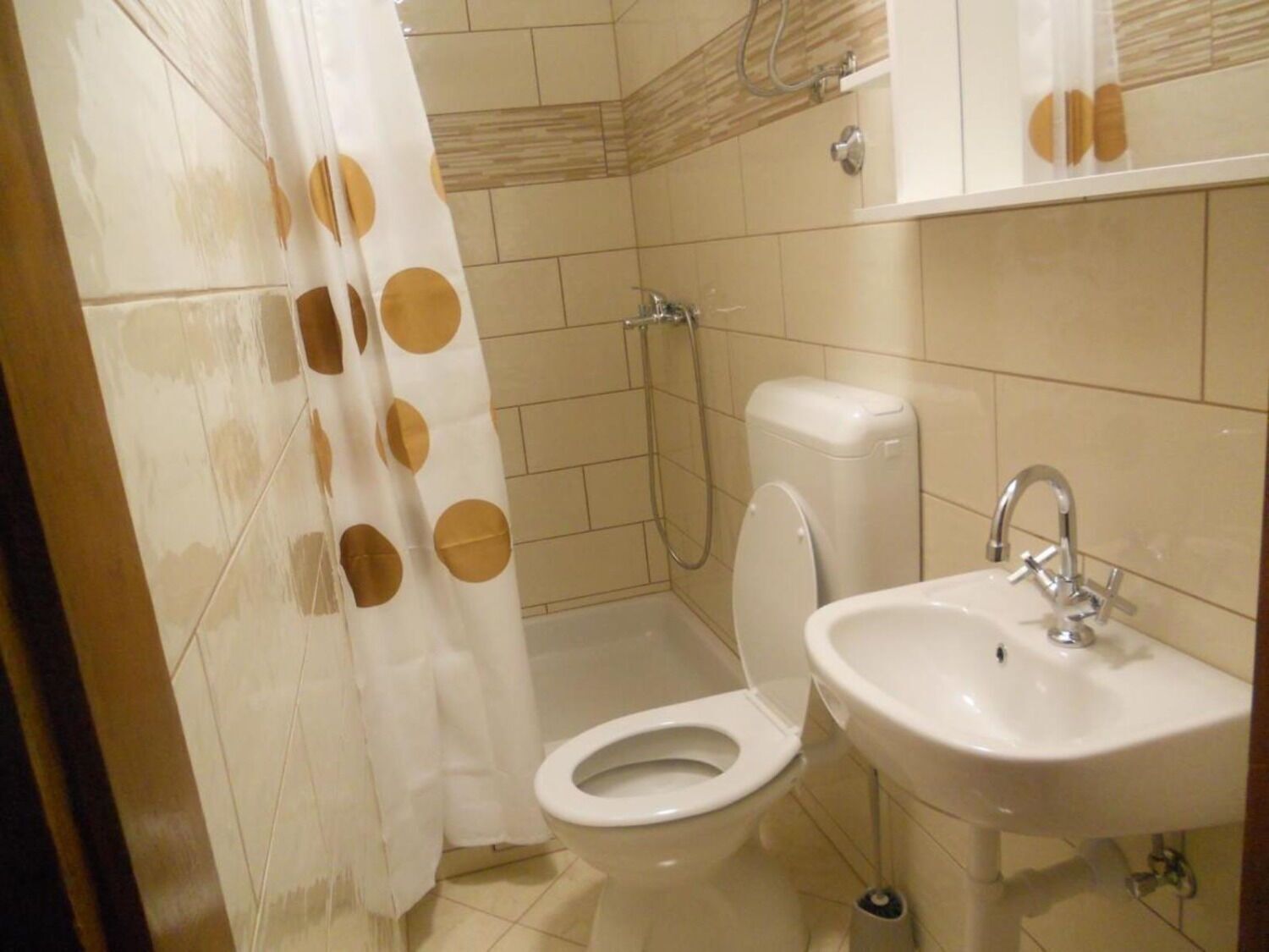 Ein kleines Badezimmer mit Toilette, Waschbecken und Dusche.
