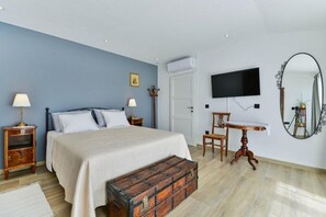 A bedroom with a bed, bedside tables, a dresser, a mirror, and a television. - House Kate (Benkovac)