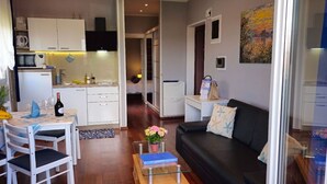 Ein kompakter Wohnbereich mit Essplatz, Küchenzeile und Wohnzimmer mit Sofa und Couchtisch.