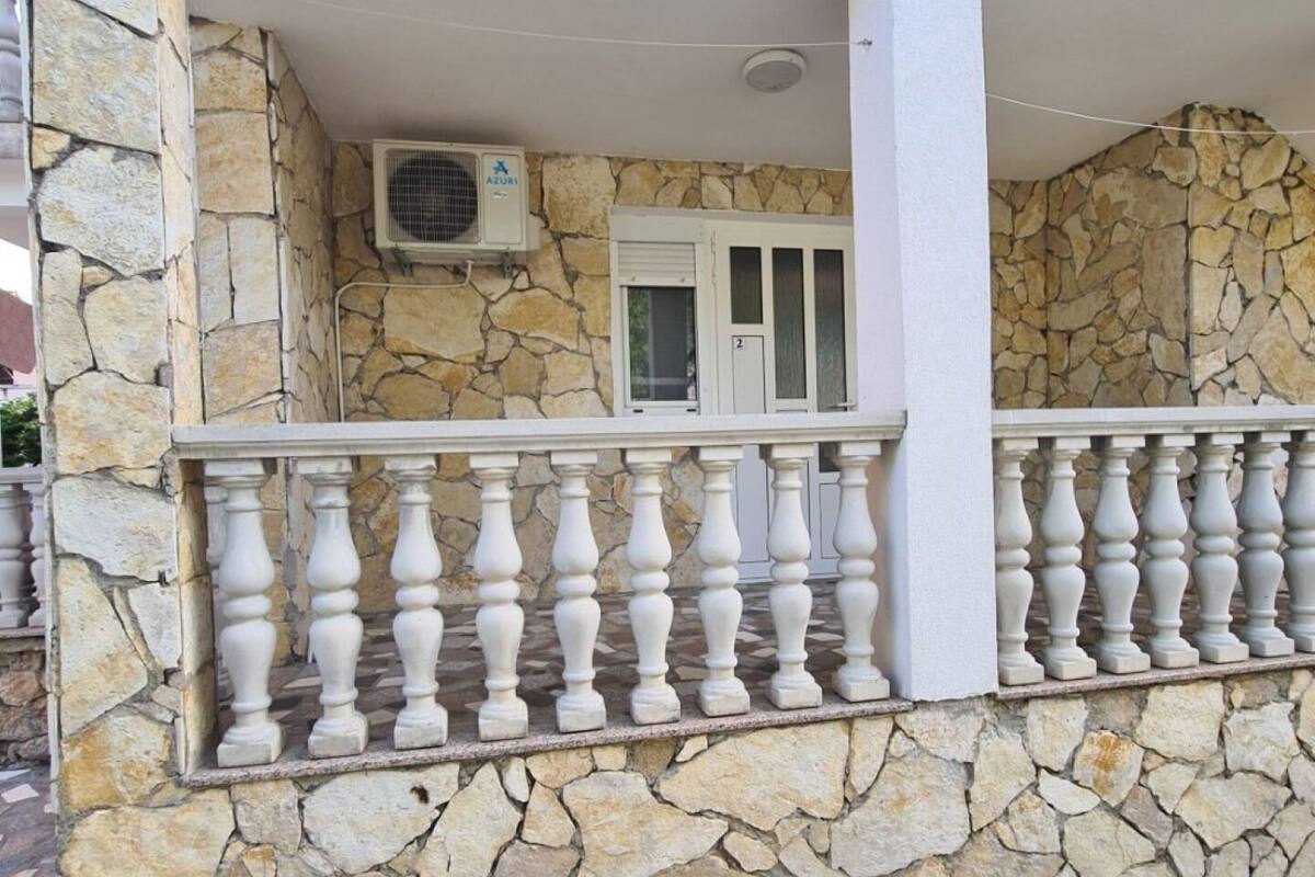 A stone facade with a balcony featuring white balustrades.