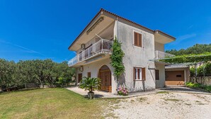 A two-story house with a balcony, a garage, and a garden. - Apartments Sunny (Makarska)