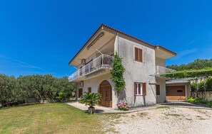 A two-story house with a balcony, a garage, and a garden. - Apartments Sunny (Makarska)