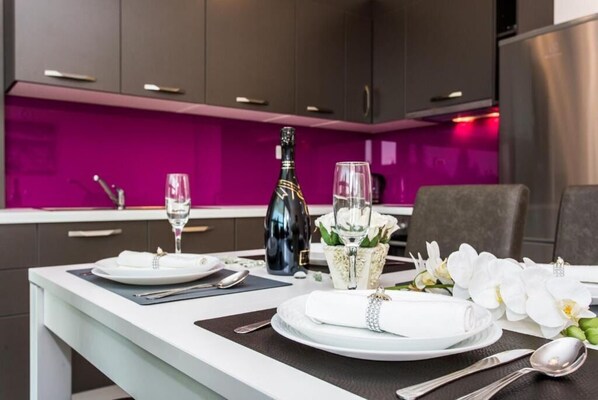 A modern kitchen with a dining area set for two. - Apartments Marina (Malinska-Dubasnica)