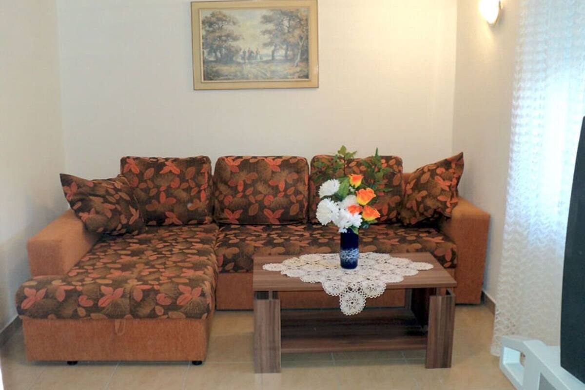 A living room with a sofa, a coffee table, and a painting on the wall.
