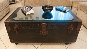 A vintage-style trunk coffee table with metal handles and wheels, placed on a tiled floor. - Apartment Vera (Solta)