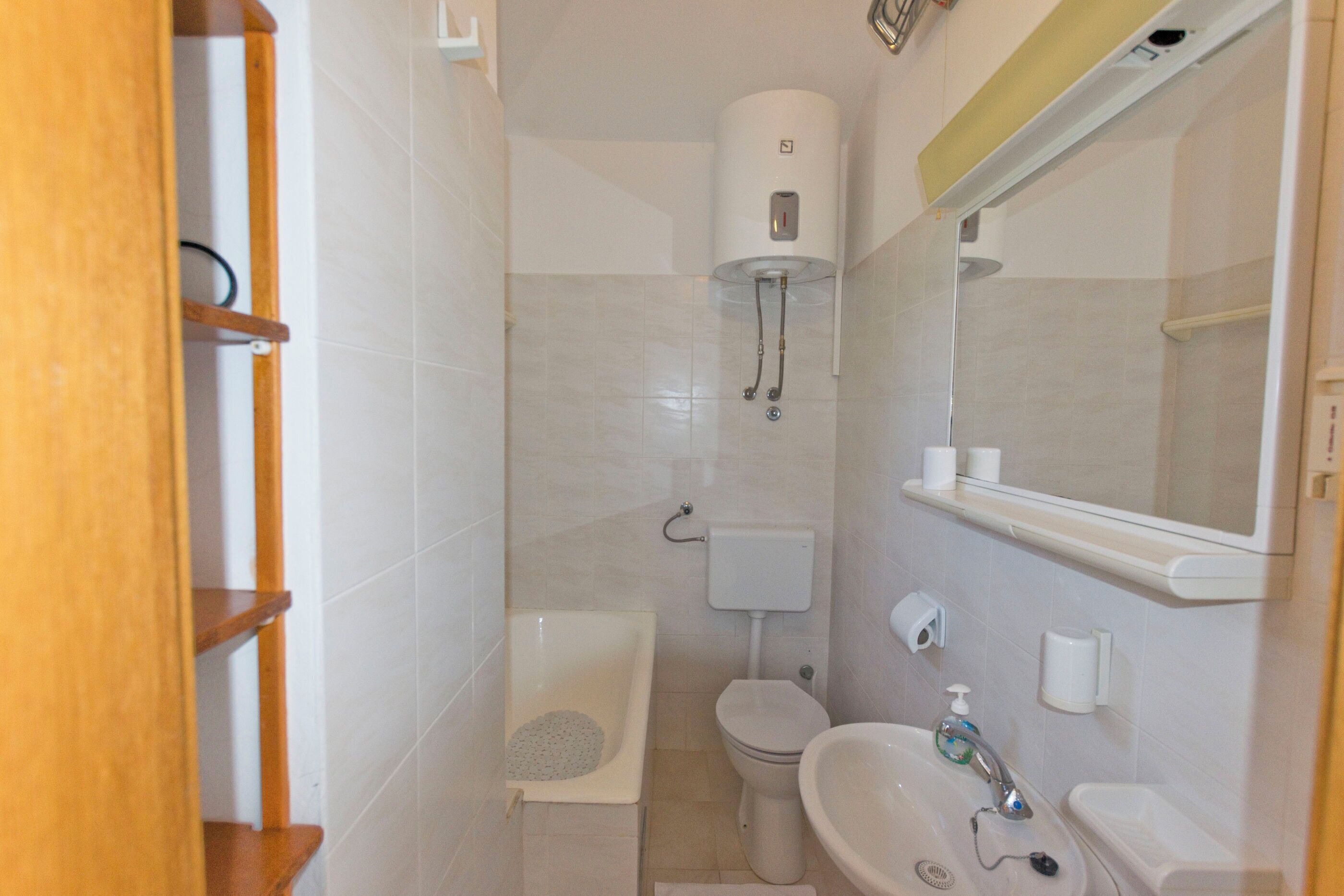 Un bagno piccolo con il water, un lavandino e una doccia.
