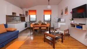 Een moderne woonruimte met keuken, eethoek en zithoek.