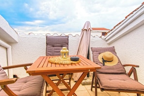 An outdoor seating area with a table, chairs, and a sun lounger. - House Katy (Posedarje)