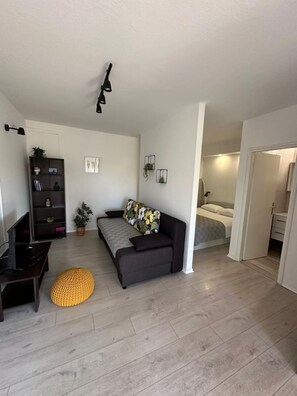 A modern living room with a sofa, a coffee table, a bookshelf, and a TV. - Apartments Ivana (Trpanj)