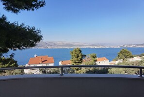 A balcony with a view of a coastal town and the sea. - Apartments Anto (Okrug)