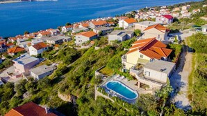Μια παραθαλάσσια οικιστική περιοχή με σπίτια, μια πισίνα και θέα στη θάλασσα.