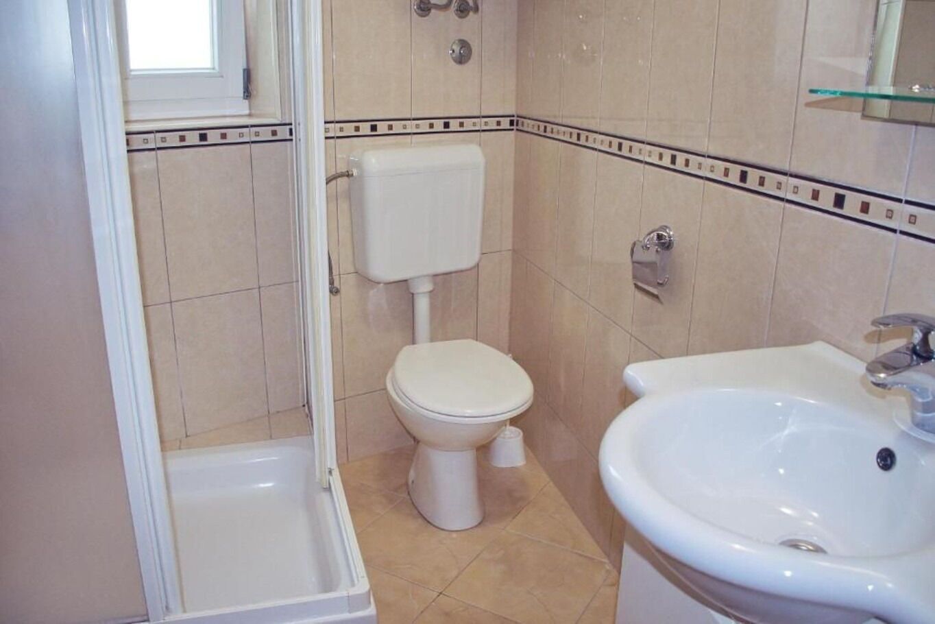 A bathroom with a toilet, a sink, and a shower.