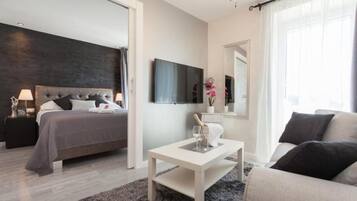 A modern bedroom with a bed, bedside table, and a large mirror.