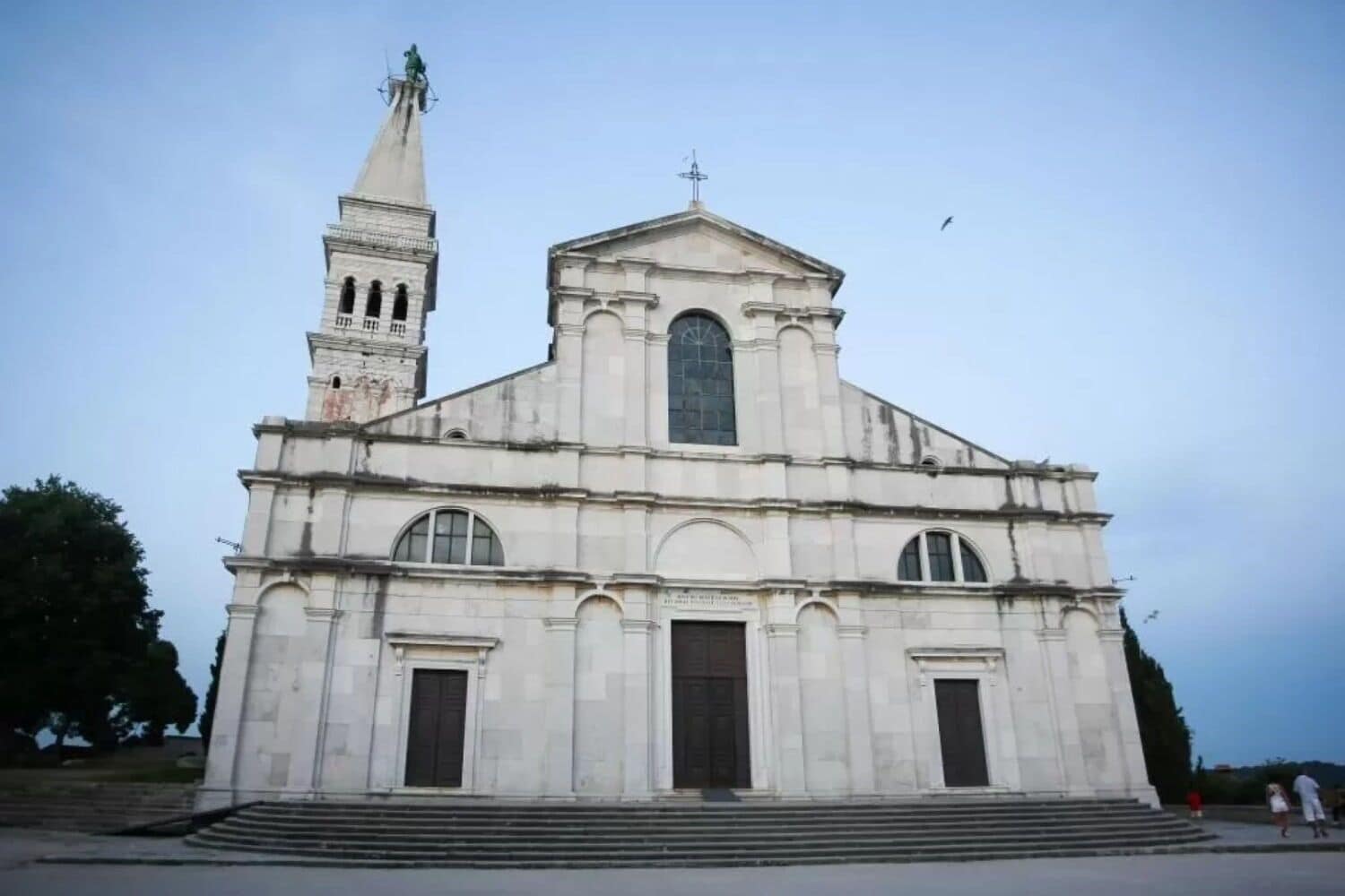 A large, historic church with a prominent bell tower and a large central window.