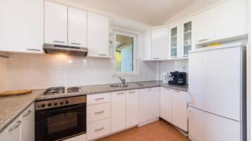 Apartment (A8) | Private kitchen | Fridge, stovetop, electric kettle, cookware/dishes/utensils