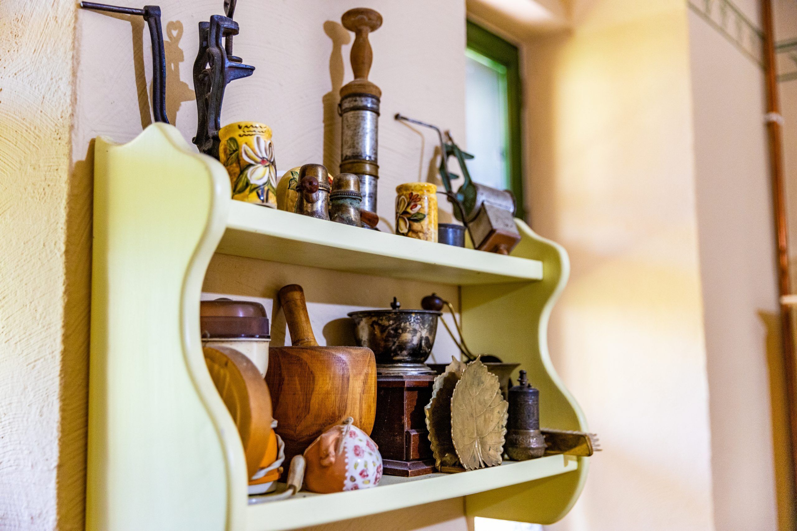 A shelf with various antique kitchen utensils and containers.