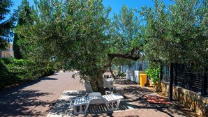 A paved pathway with outdoor seating, trees, and a fence. - Apartments Bionda (Sibenik)