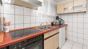 A kitchen with a built-in stove, a sink, and a dishwasher. - Apartments Zorica (Omis)