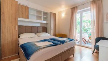 Ein Schlafzimmer mit Bett, Schrank, Tisch und Stuhl.