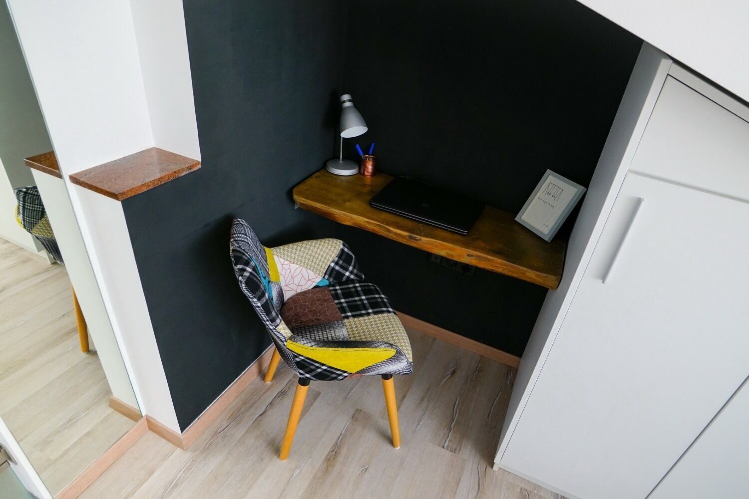 A compact workspace with a desk, chair, and shelving unit.