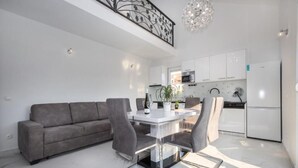 Une cuisine moderne avec des meubles blancs, un four à micro-ondes et un réfrigérateur.