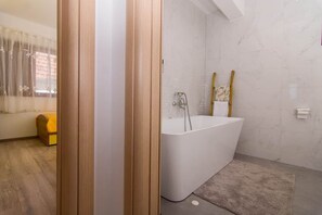 Une salle de bain avec une baignoire, une douche et des toilettes.