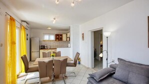 Un appartement moderne comprenant un coin repas, une cuisine et un salon.