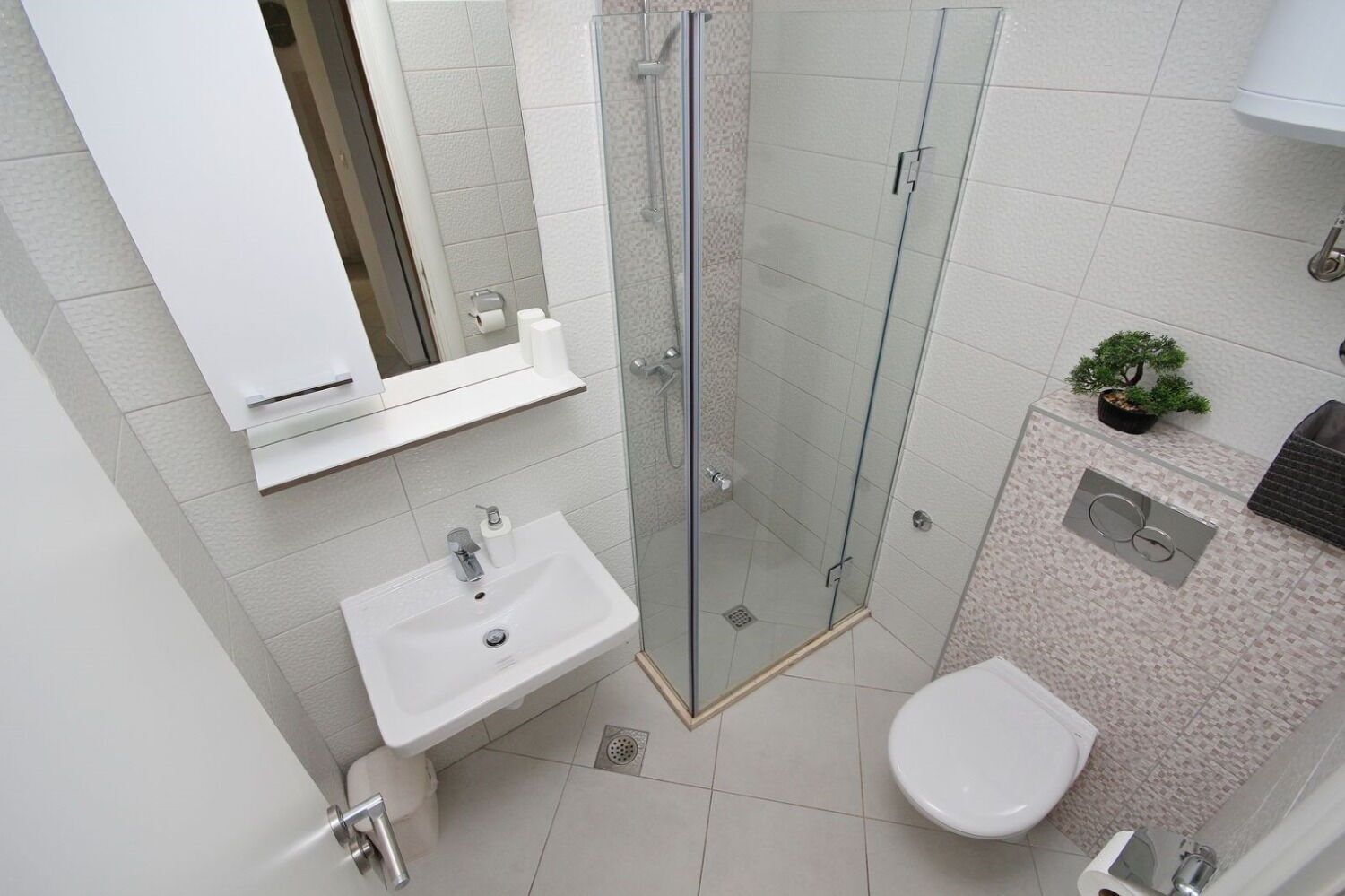 Ein modernes Badezimmer mit einer Duschkabine, einem Waschbecken und einer Toilette.