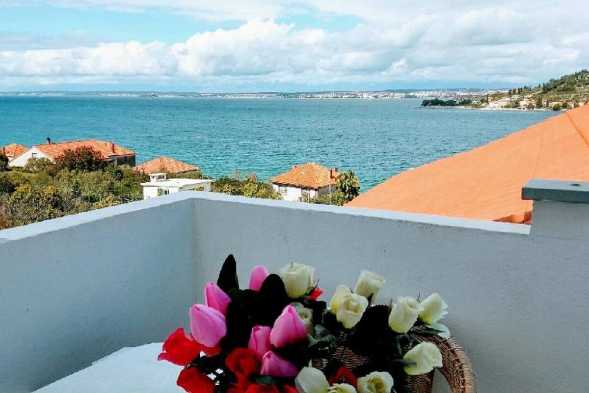 A balcony with a view of the sea and a coastal town.