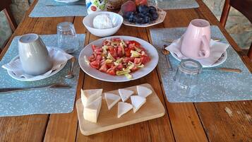 Uma mesa de madeira posta com pratos de comida, um jarro e uma caneca.