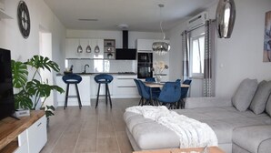Un salon moderne avec un canapé gris, une table basse en bois et un meuble pour la télévision.