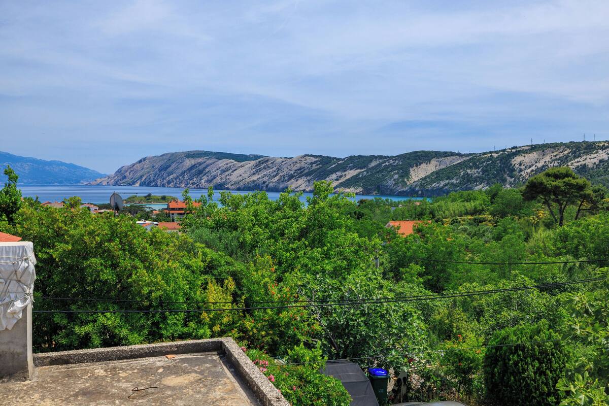 Un paysage côtier offrant une vue sur la mer et les collines.