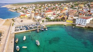 An aerial view of a coastal town with a marina, houses, and a beach. - House Dali (Razanac)