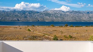 A view of a mountainous landscape with a clear sky and a body of water in the foreground. - House Dali (Razanac)