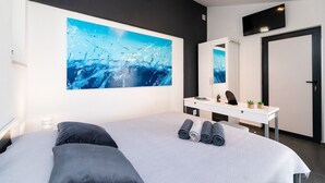A modern bedroom with a large bed, a desk, a mirror, and a wall-mounted TV. - House Fani (Postira)