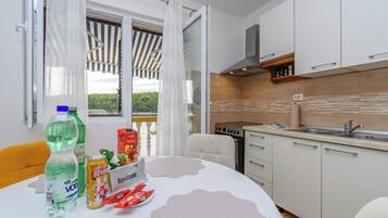 Ett modernt kök med vita skåp, en inbyggd ugn och en diskho.