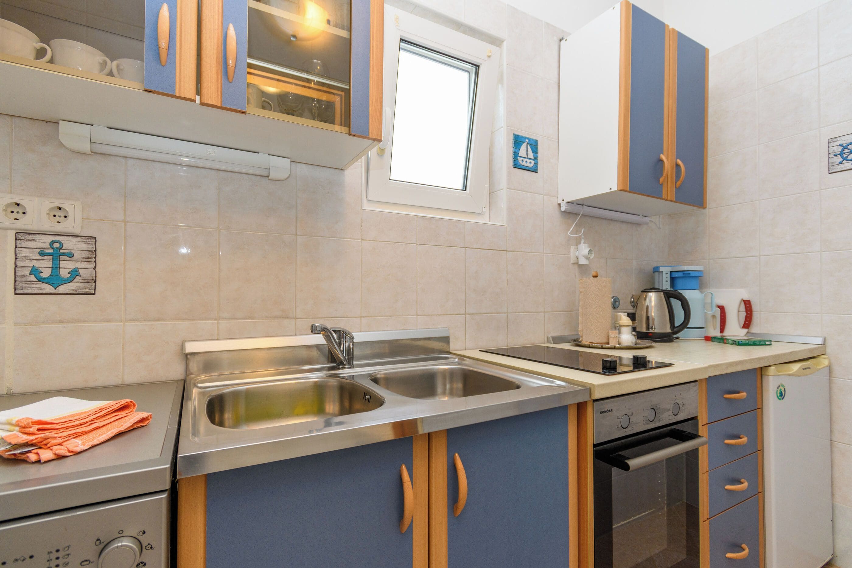 A modern kitchen with a double sink, stainless steel appliances, and wooden cabinets.