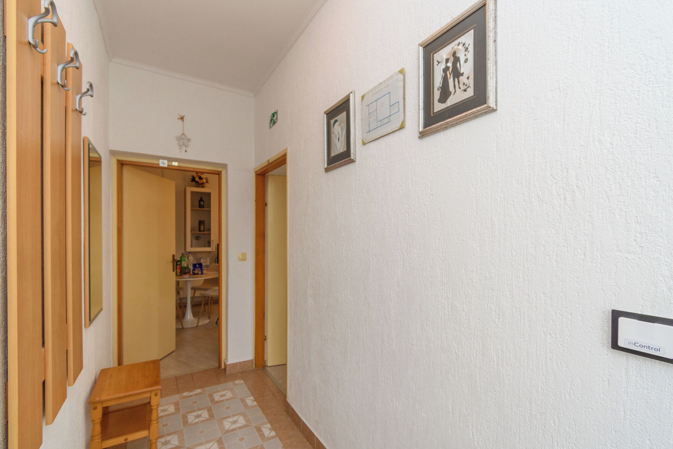 A hallway with wooden doors, a small table, and a wall-mounted sign.