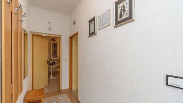 A hallway with wooden doors, a small table, and a wall-mounted sign.