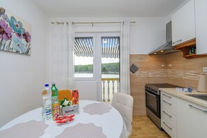 Et kompakt køkken med komfur, ovn og en lille bordplade.