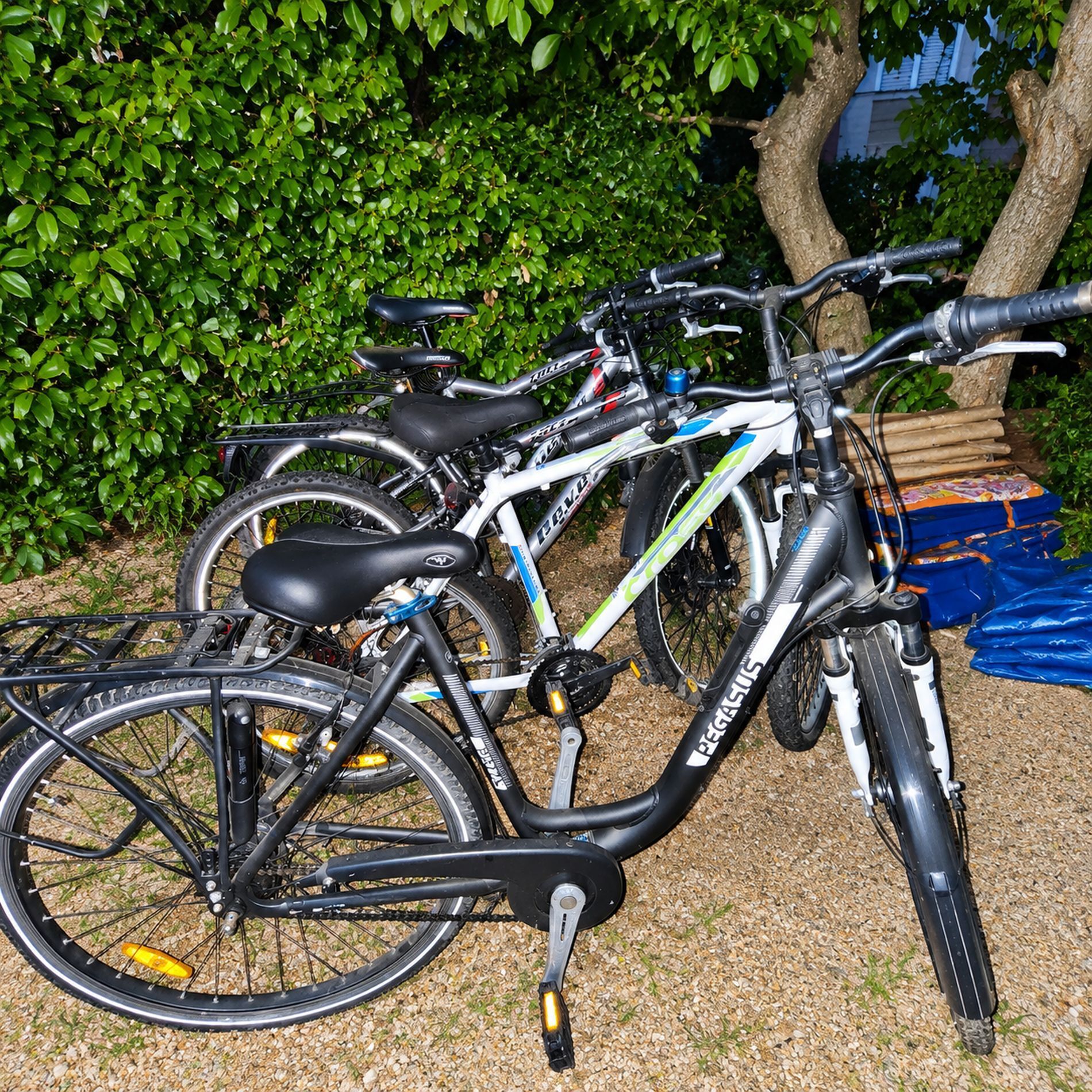 Un vélo garé à l’extérieur, sur une surface de gravier, avec de la verdure en arrière-plan.