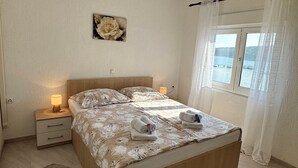 Ein Schlafzimmer mit einem hölzernen Bett, einem Nachttisch mit Lampe, einem Teppich und einem Gemälde an der Wand.