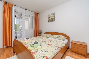Et soveværelse med en træseng, blomstret sengetøj, et natbord, en lampe og et billede på væggen.