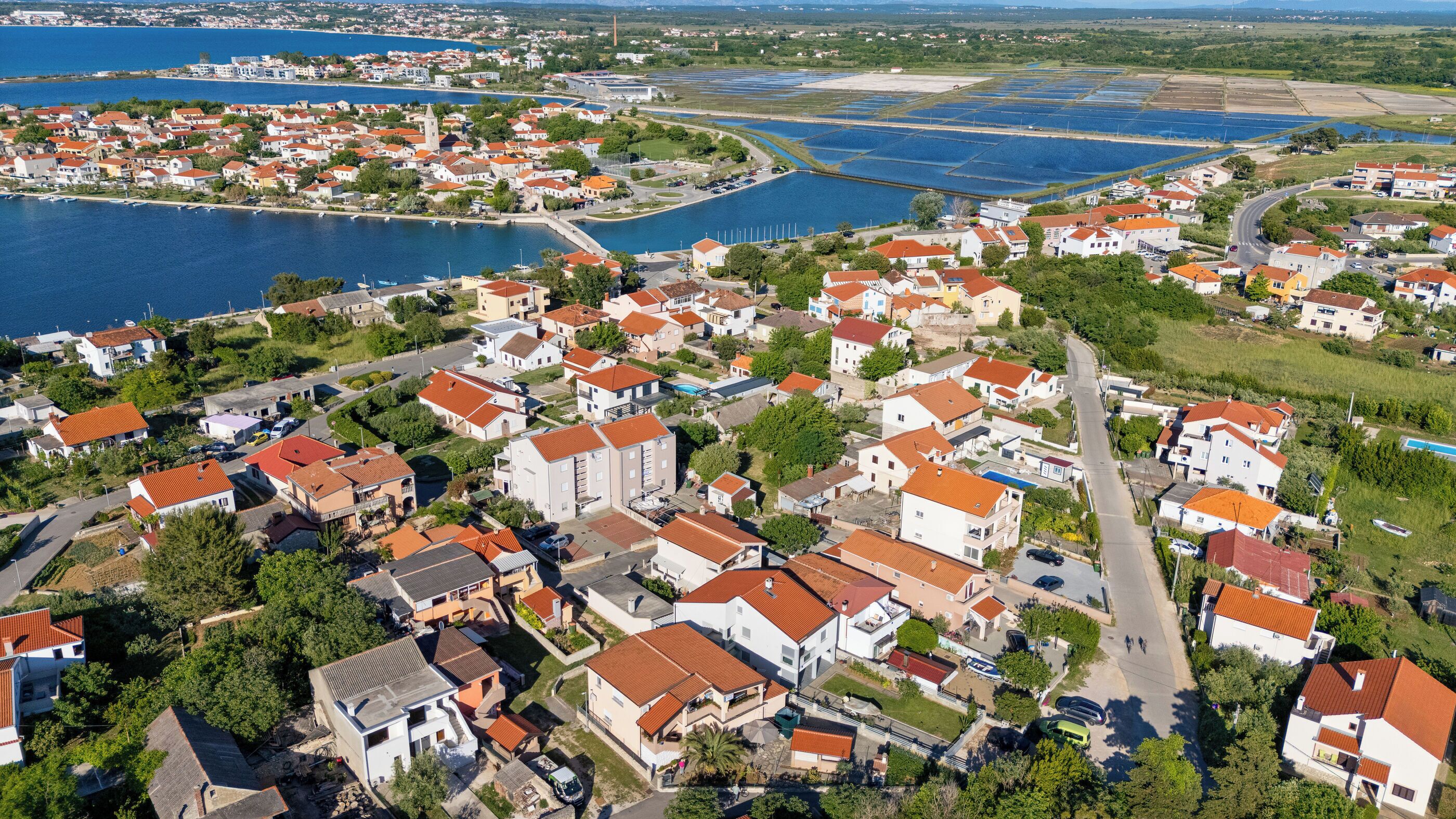 A coastal town with a marina, residential buildings, and a large body of water.