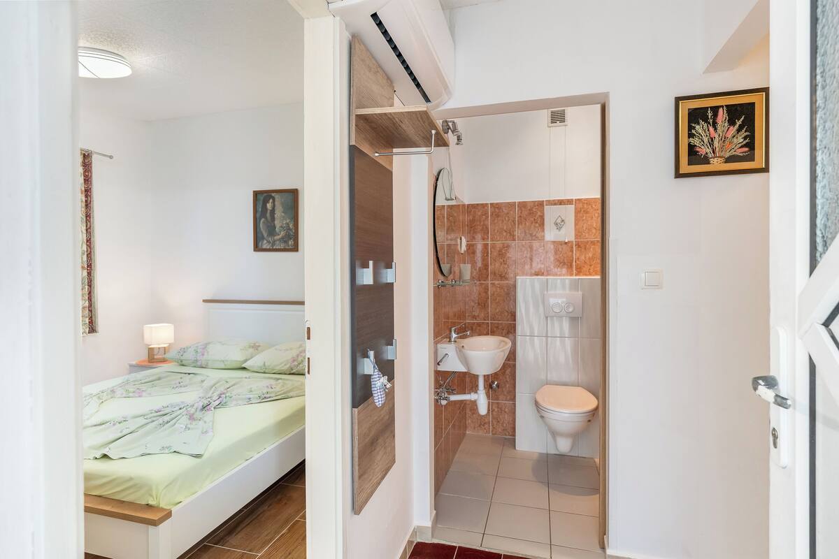 A bedroom with a bed, a nightstand, and a bedside lamp.