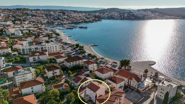 A coastal town with white buildings, a marina, and a beach. - Apartments Tabak (Okrug)