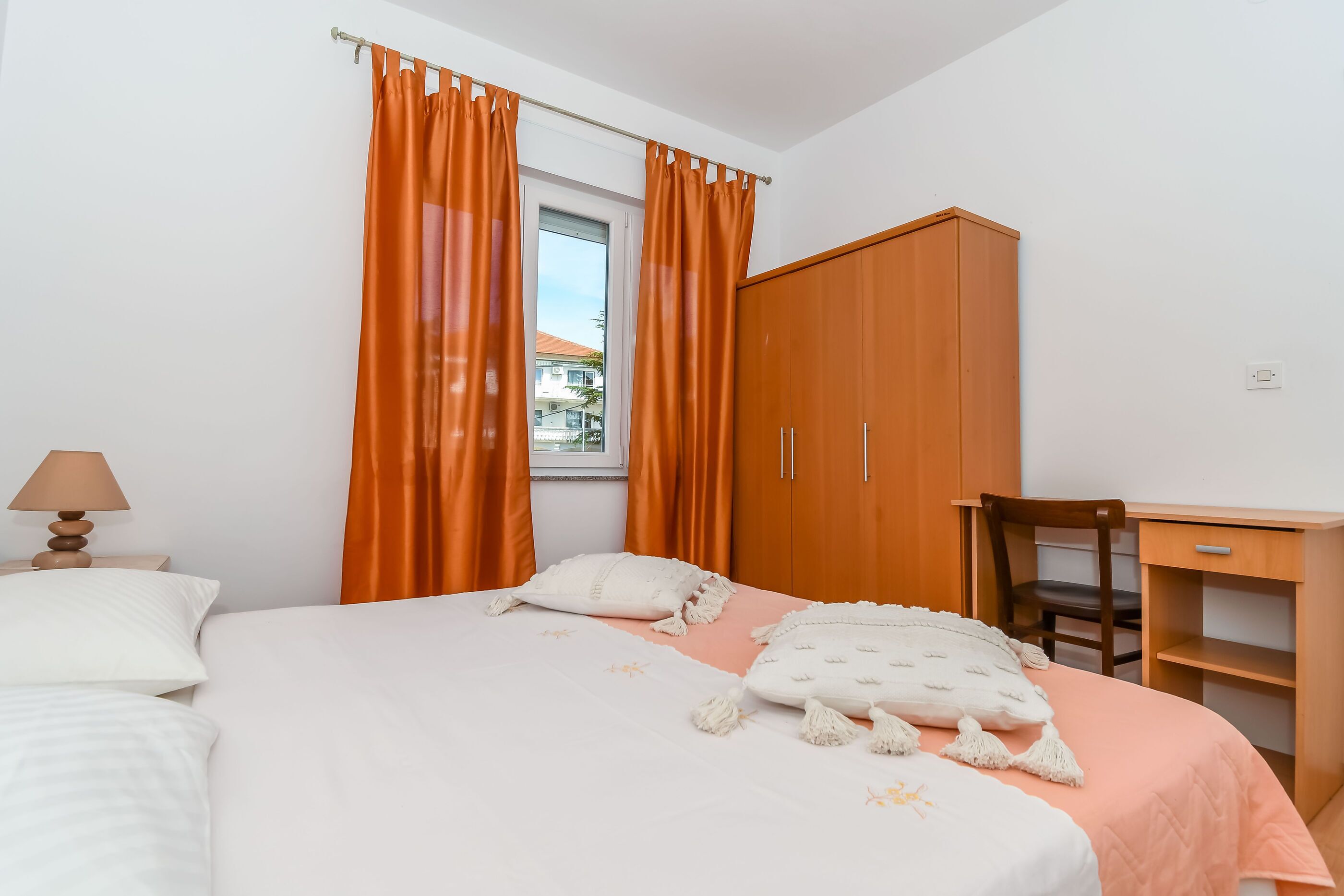 Un dormitorio con cama, escritorio y armario.