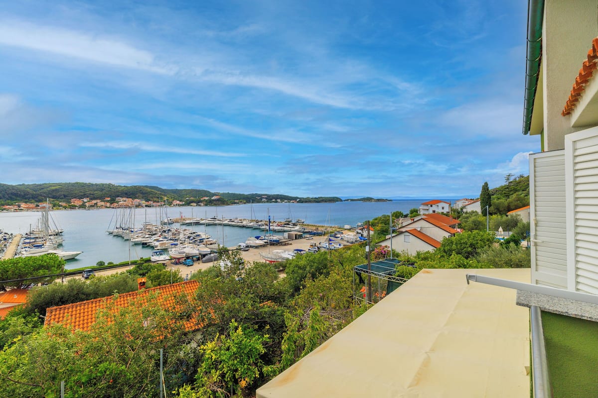 A marina with boats, a clear sky, and buildings in the background.