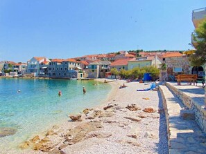 A coastal town with stone buildings, clear waters, and a pebble beach. - Apartments Jakov (Postira)