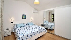 Un dormitorio con cama, mesitas de noche, un espejo y una lámpara de techo.